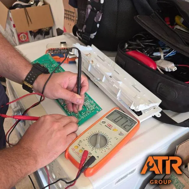 Dryer control board diagnosis in Houston Technician diagnosing dryer control board with multimeter in Houston home
